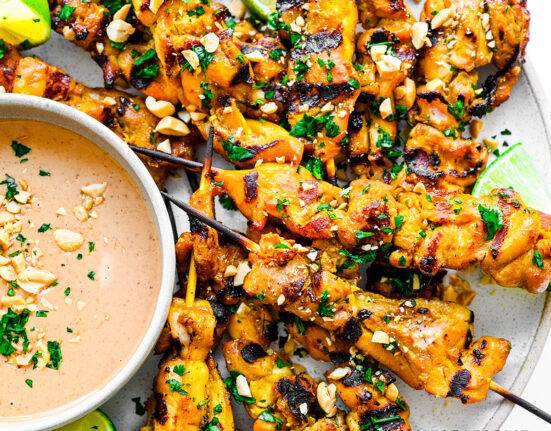 Chicken satay on a plate.