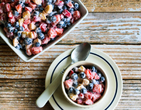 Square image of Red White and Blue Salad in serving bowl and one serving in front.