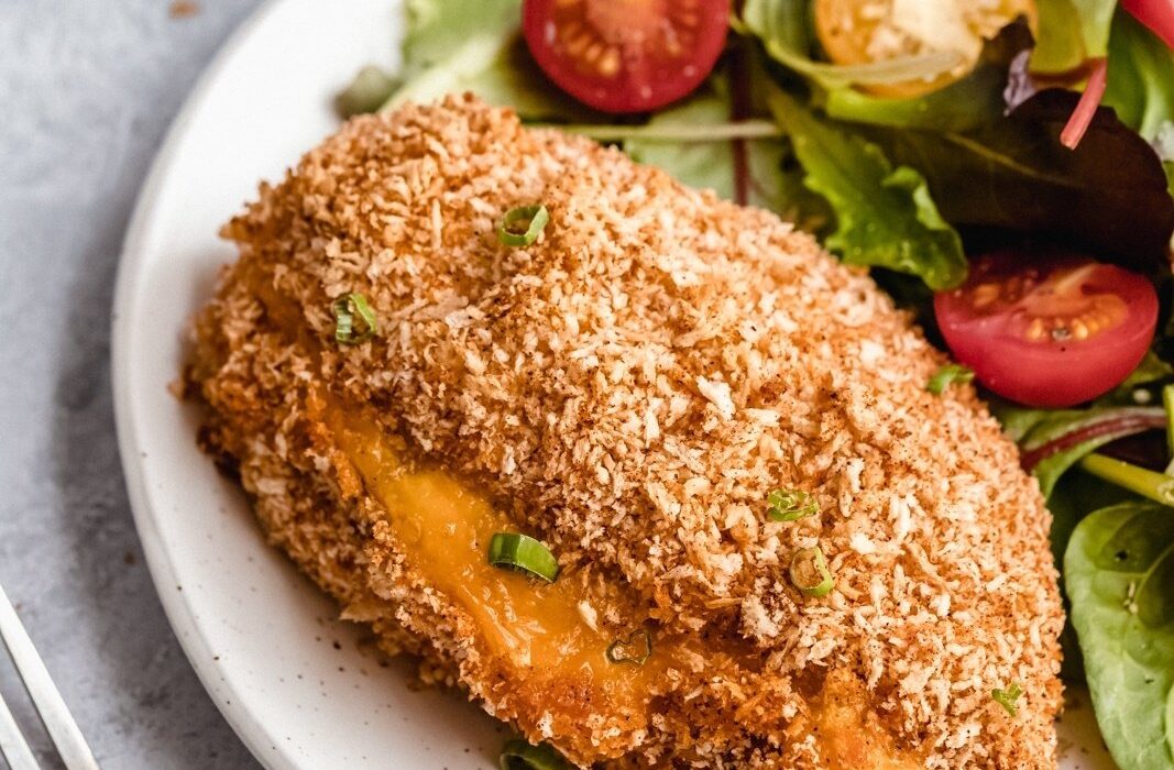 jalapeño popper stuffed chicken breast on a plate with a salad