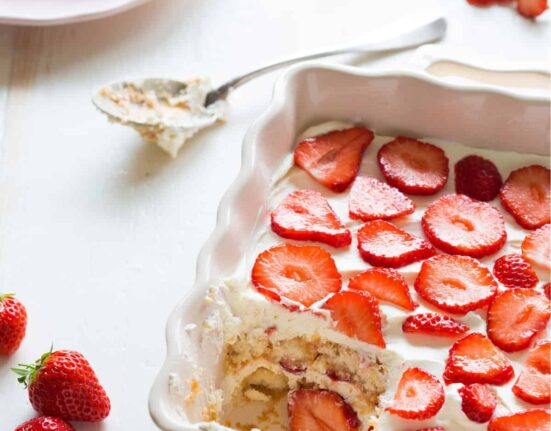 Close up image of Strawberry Tiramisu in a baking dish with a portion missing