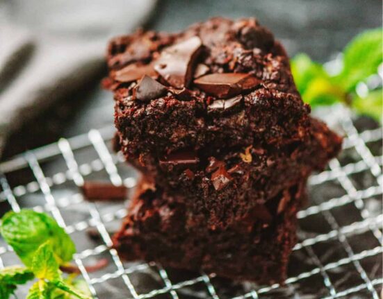 A stack of zucchini brownies on a wire cooling rack