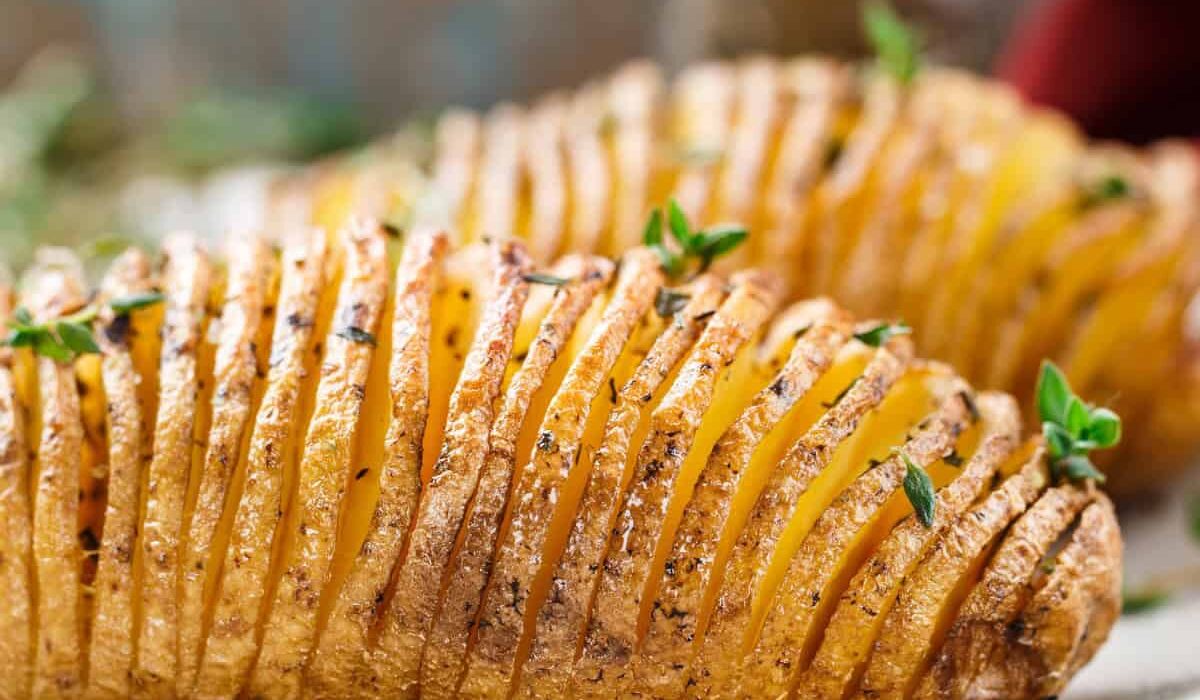 Two Hasselback Potatoes on a white plate