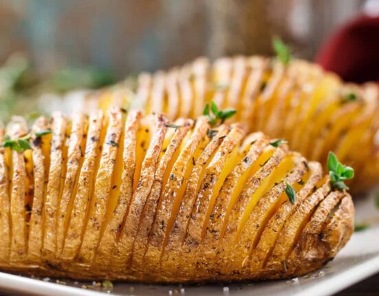 Two Hasselback Potatoes on a white plate