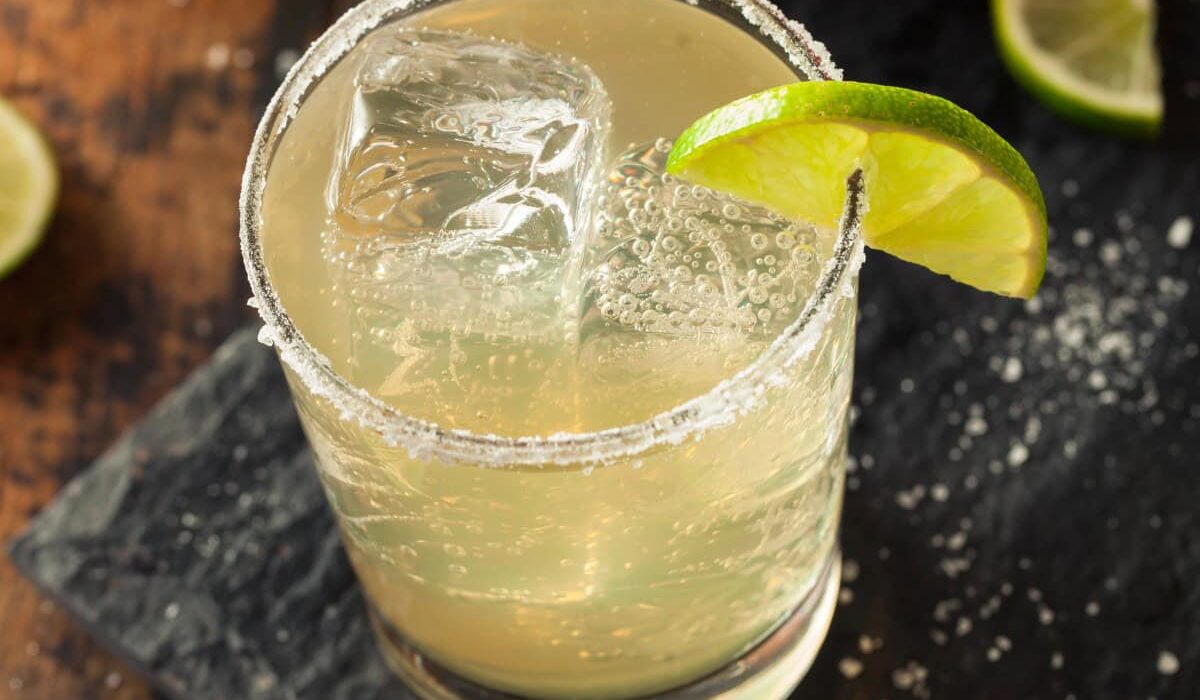 overhead image of a nonalcoholic margarita on a cutting board with lime and salt