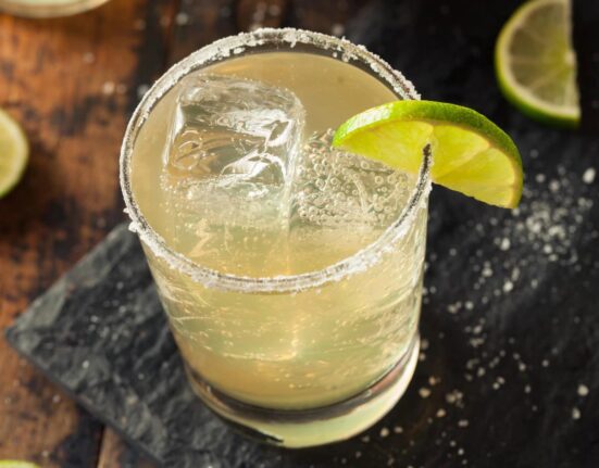 overhead image of a nonalcoholic margarita on a cutting board with lime and salt