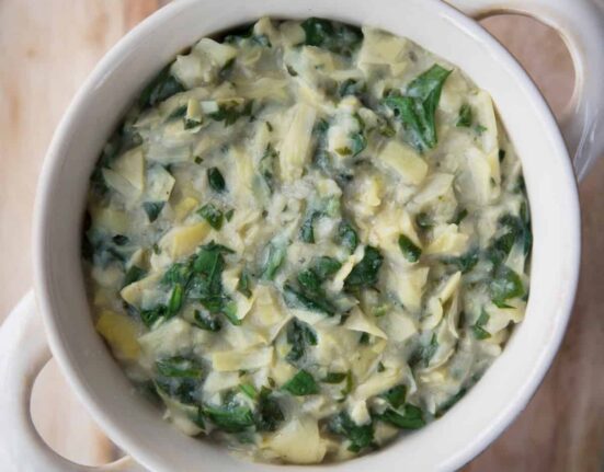 Overhead image of Vegan Spinach Artichoke Dip in a white crock