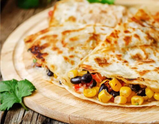 Black Bean Quesadilla cut into pieces on a round cutting board
