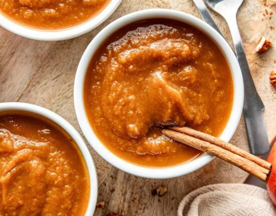 Overhead view of two small bowls of fresh crockpot pumpkin applesauce.
