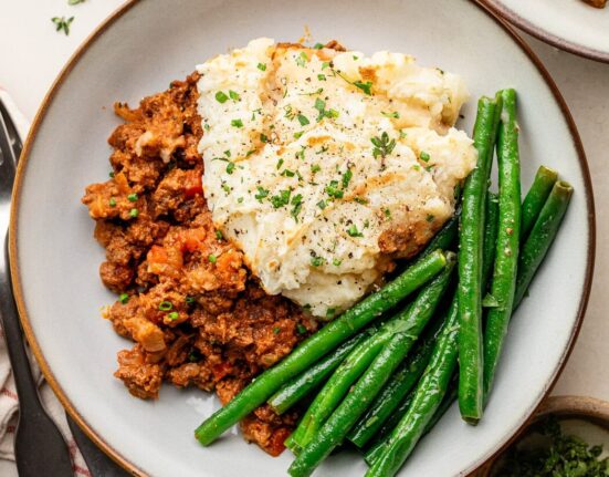 Overhead view of a plate of Sloppy Joe Casserole with green beans on the side.