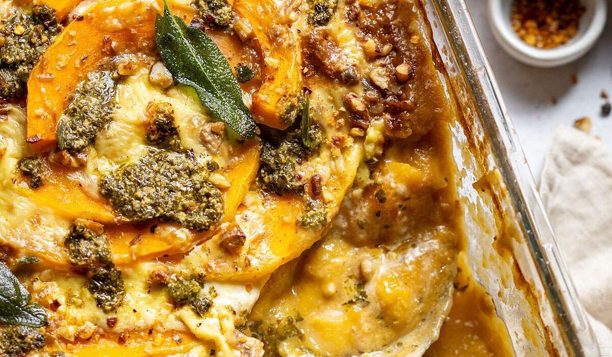 A serving spoon in a butternut squash gnocchi casserole dish.