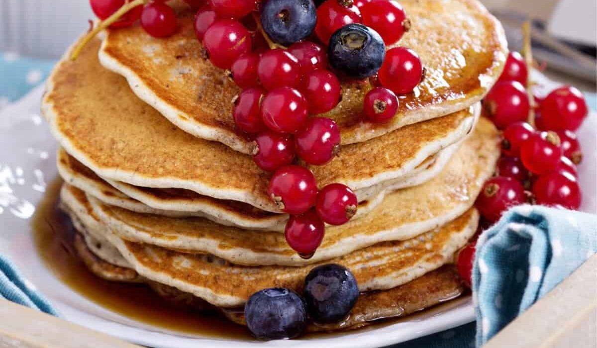 Close up image of a stack of Vegan Pancakes with berries on top
