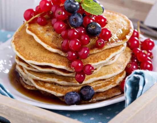 Close up image of a stack of Vegan Pancakes with berries on top