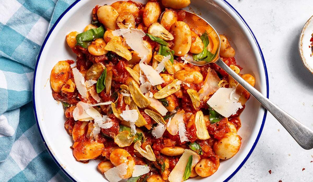 Spicy arrabbiata beans on a plate with a spoon.