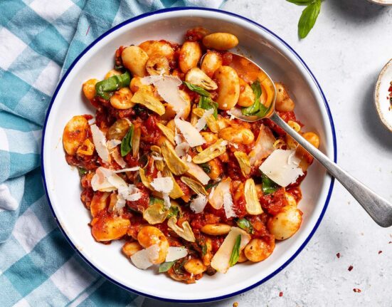 Spicy arrabbiata beans on a plate with a spoon.
