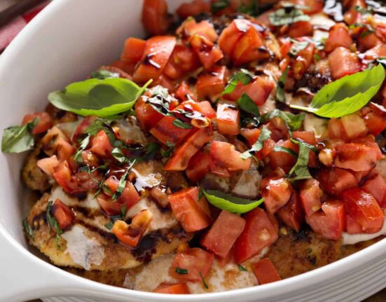 A pan of bruschetta chicken in a white baking dish