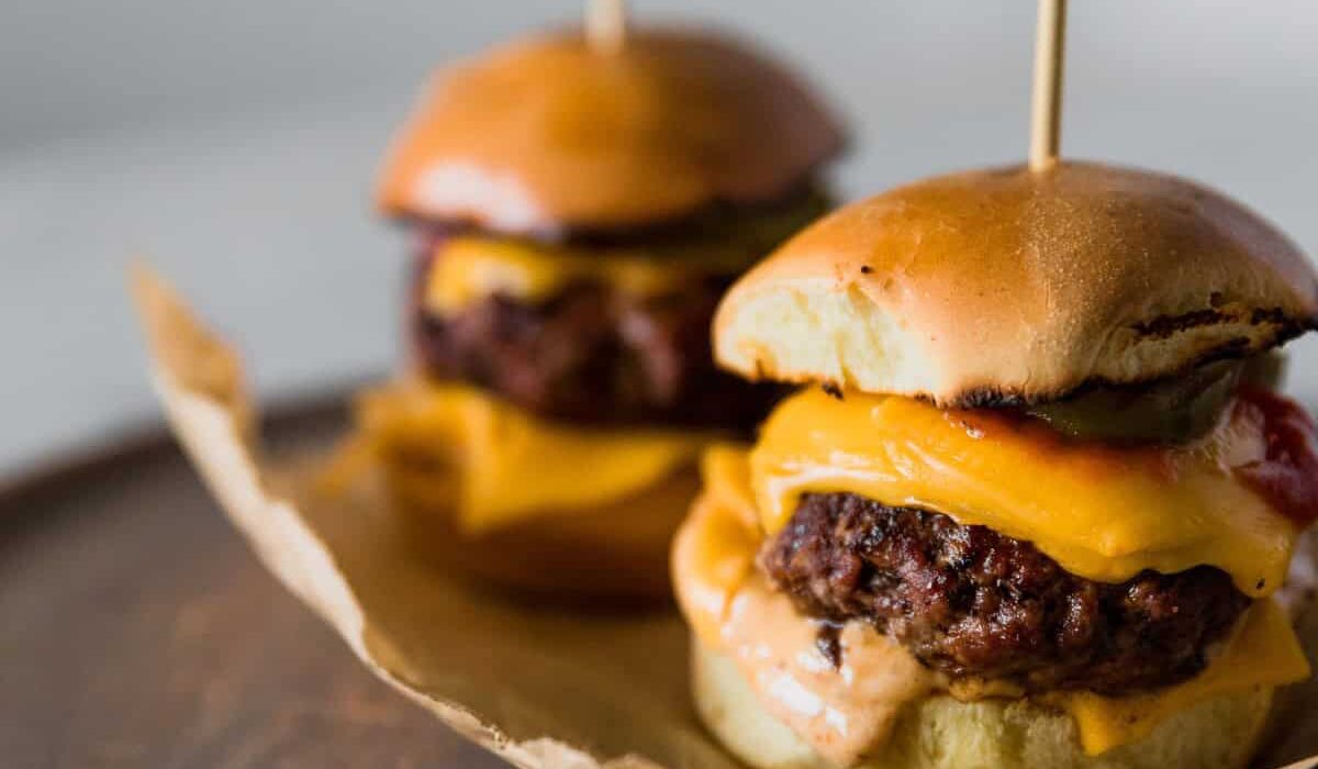 Two Cheeseburger Sliders on parchment paper