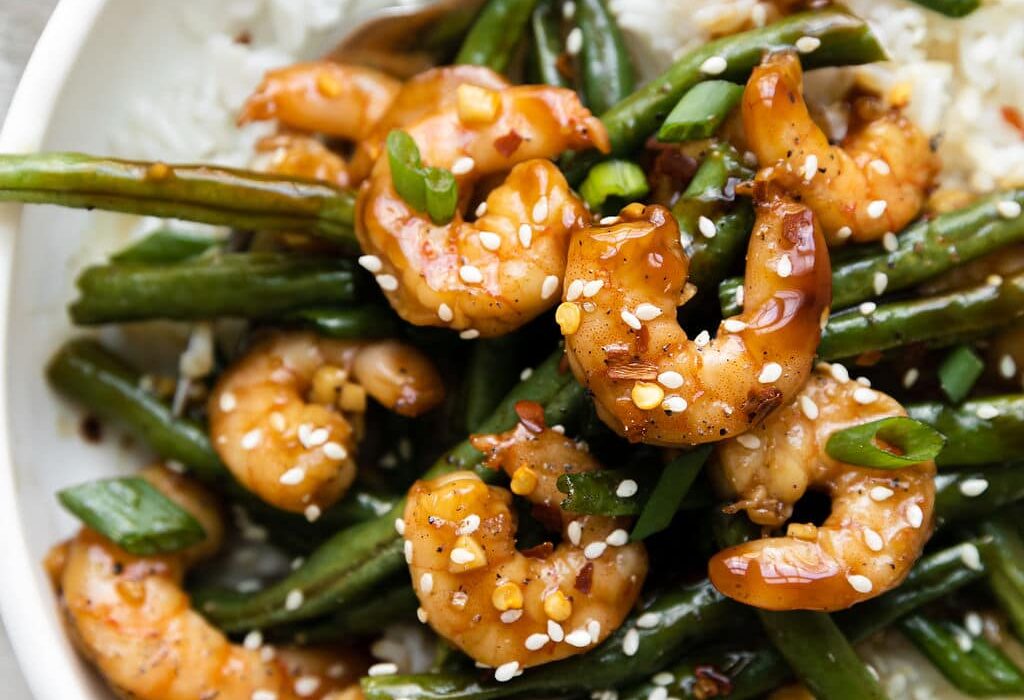 Close up view of a bowl of Sheet Pan Honey Garlic Shrimp over rice.