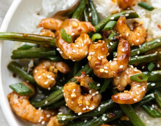 Close up view of a bowl of Sheet Pan Honey Garlic Shrimp over rice.