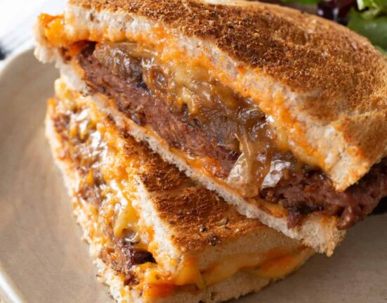 A Patty Melt Sandwich on a plate with salad on the side