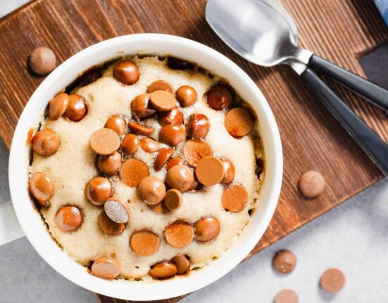 Overhead image of a chocolate chip mug cake on a wooden cutting board