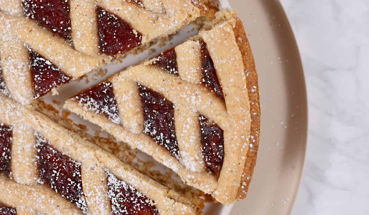 Overhead image of a piece being taken out of a linzer tart
