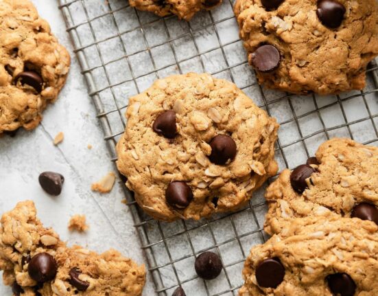 Close up view of freshly baked Peanut Butter Oatmeal Cookies with Chocolate Chips on a wire cooling rack.