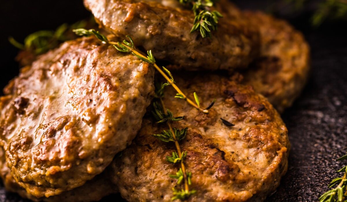 Air Fryer Sausage Patties on a black plate with herb garnish