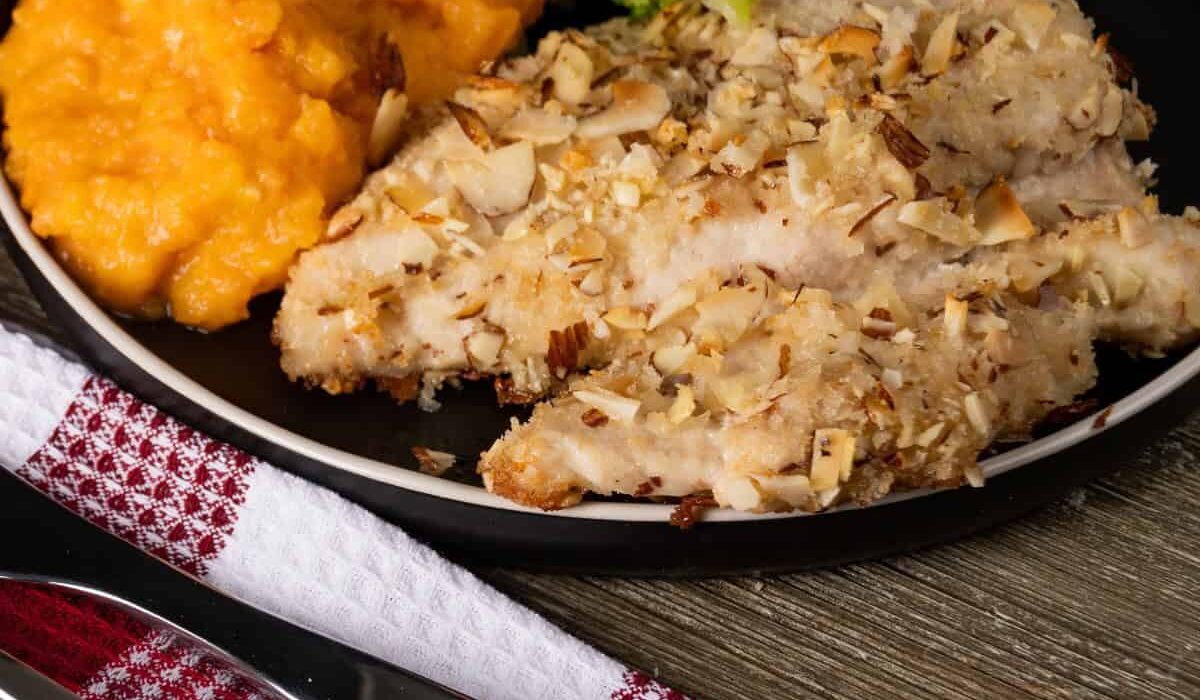 Almond Crusted Chicken on a plate with side dishes