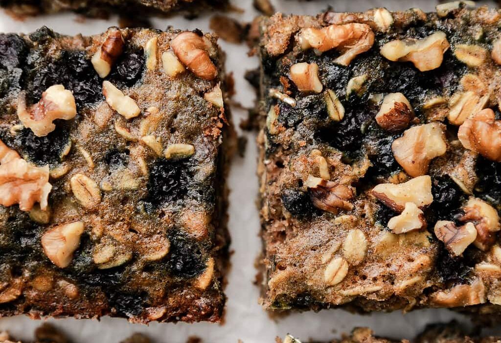 Close up overhead view oatmeal breakfast bars with wild blueberries and walnuts cut into squares