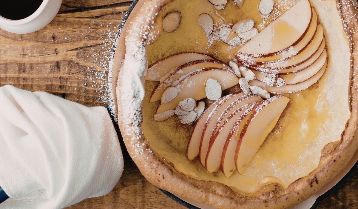 Overhead image of  Dutch Baby in a skillet with apples and almonds