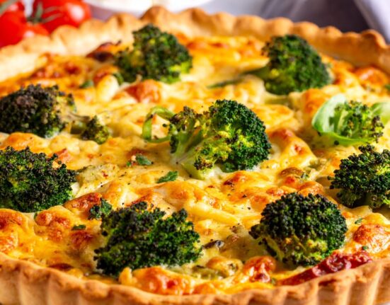 A Broccoli Quiche uncut on a white plate
