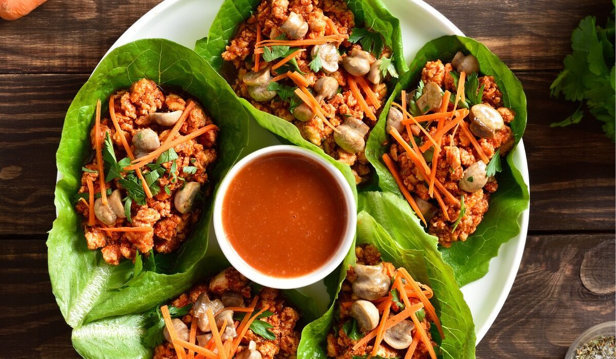 Korean Lettuce Wraps on a plate with a dipping sauce in the middle