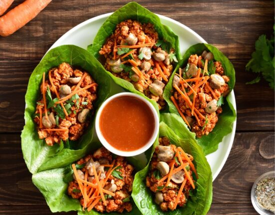 Korean Lettuce Wraps on a plate with a dipping sauce in the middle