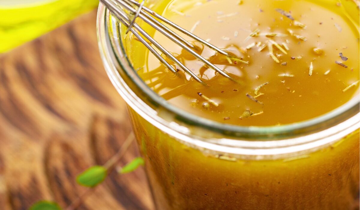 Lemon Vinaigrette in a glass jar with a small whisk