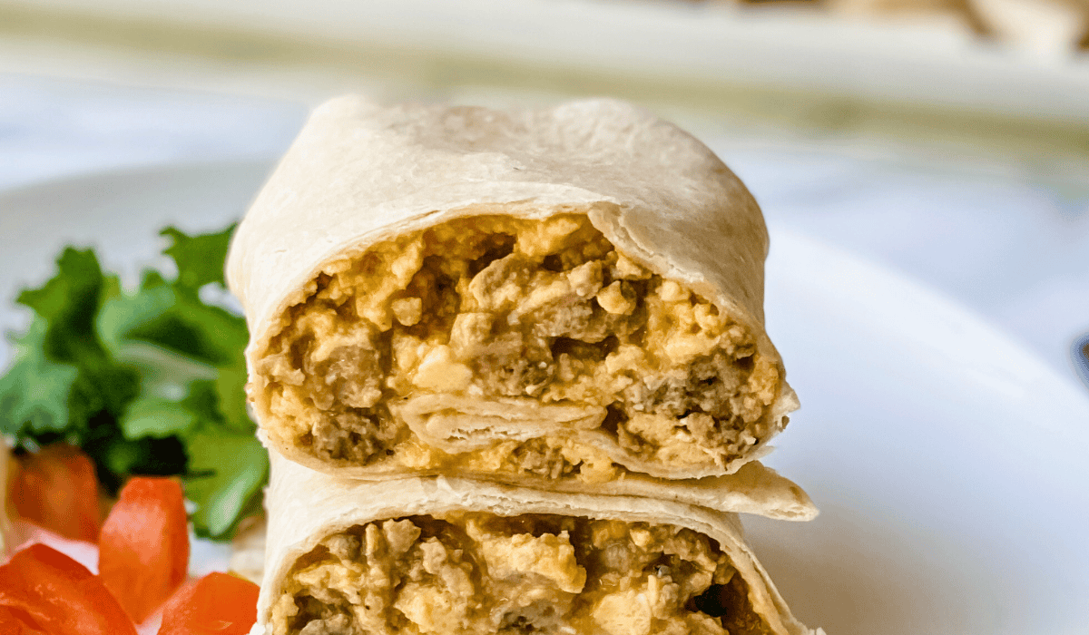 sausage and egg breakfast burrito on a plate.