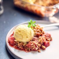 Strawberry Rhubarb Crisp on a plate with ice cream