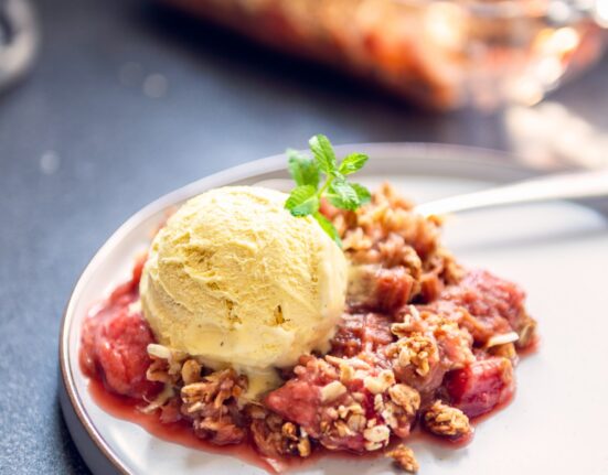 Strawberry Rhubarb Crisp on a plate with ice cream