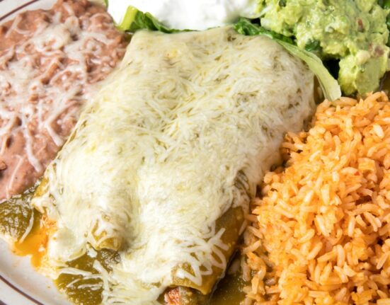 Overhead image of Turkey Enchiladas on a plate with beans and rice