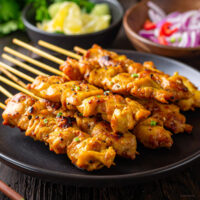 Close up image of Chicken Satay stacked on a plate
