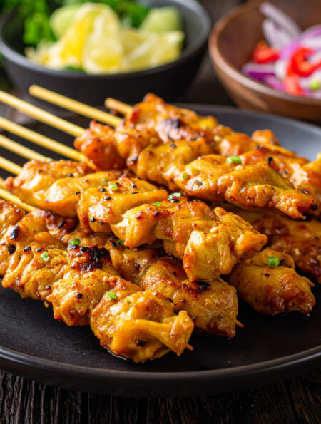 Close up image of Chicken Satay stacked on a plate
