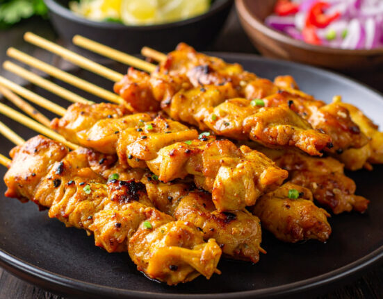 Close up image of Chicken Satay stacked on a plate