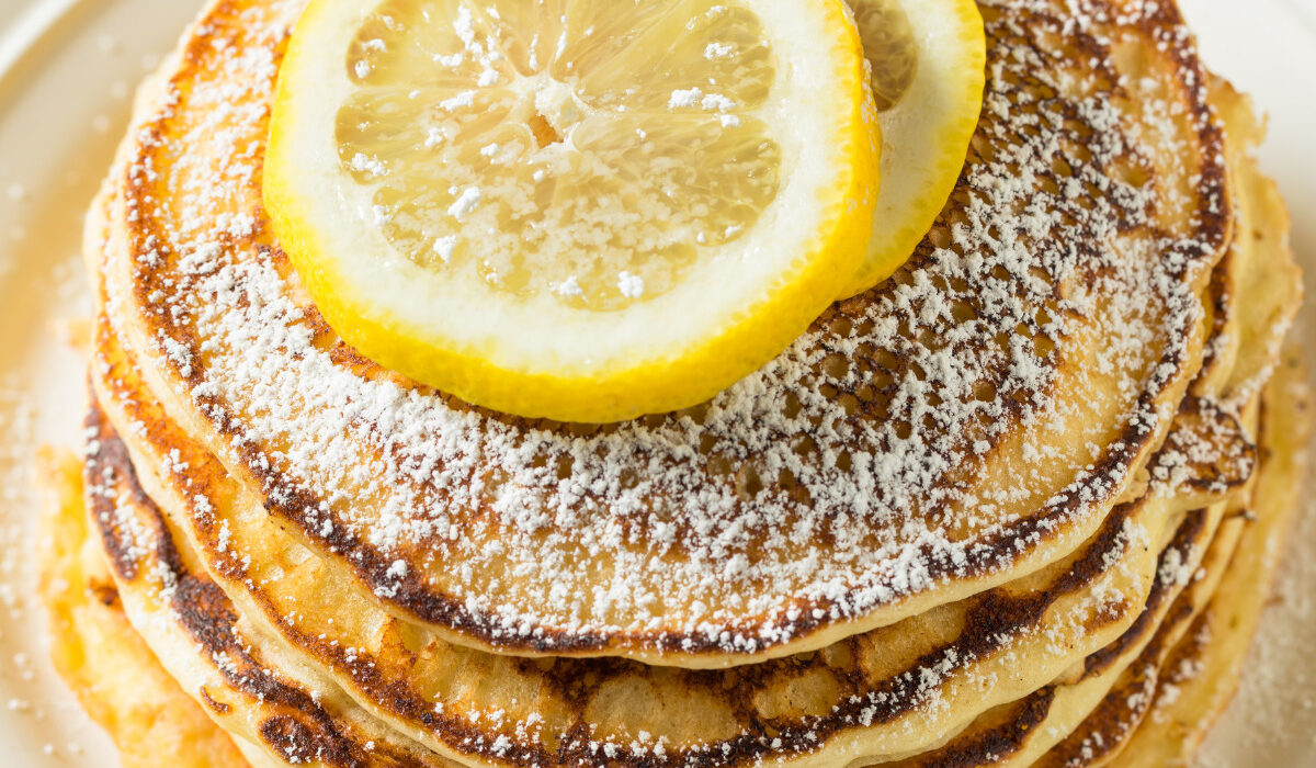 Overhead image of lemon ricotta pancakes with slices of lemon on top