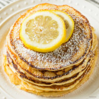 Overhead image of lemon ricotta pancakes with slices of lemon on top