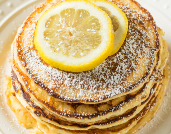 Overhead image of lemon ricotta pancakes with slices of lemon on top
