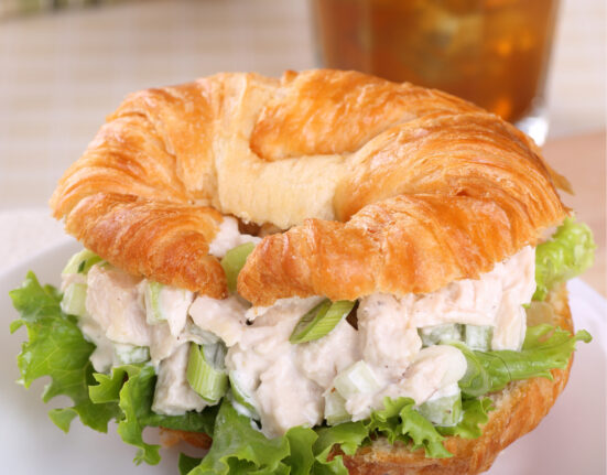 A chicken salad sandwich on a croissant with lettuce