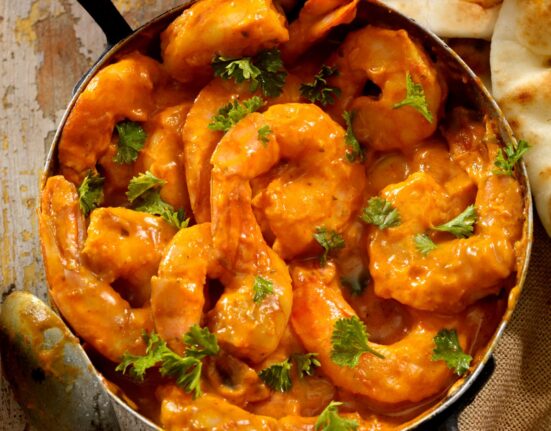 Overhead image of Curry Shrimp in a pan with cilantro for garnish