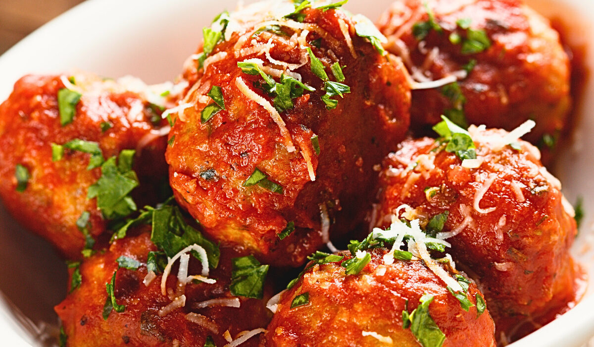 Close up image of slow cooker meatballs in a white bowl