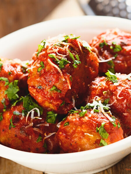 Close up image of slow cooker meatballs in a white bowl