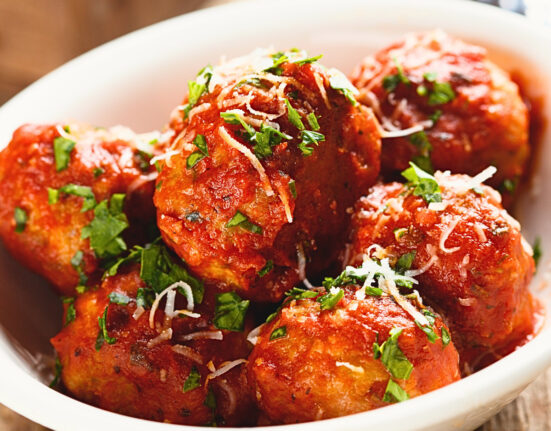 Close up image of slow cooker meatballs in a white bowl