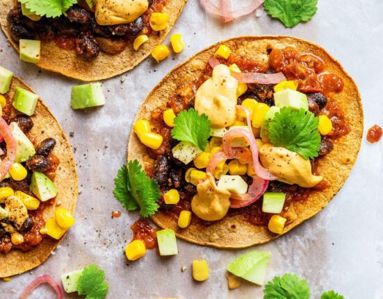 Vegan tostadas with black beans, sweetcorn, salsa, pickled onions, cilantro and vegan nacho cheese sauce.
